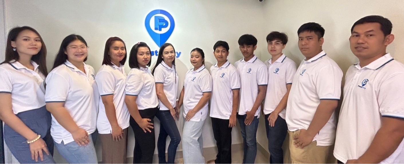 ทีมงาน PostPerty Agent ยืนเรียงกันหน้าโลโก้บริษัท